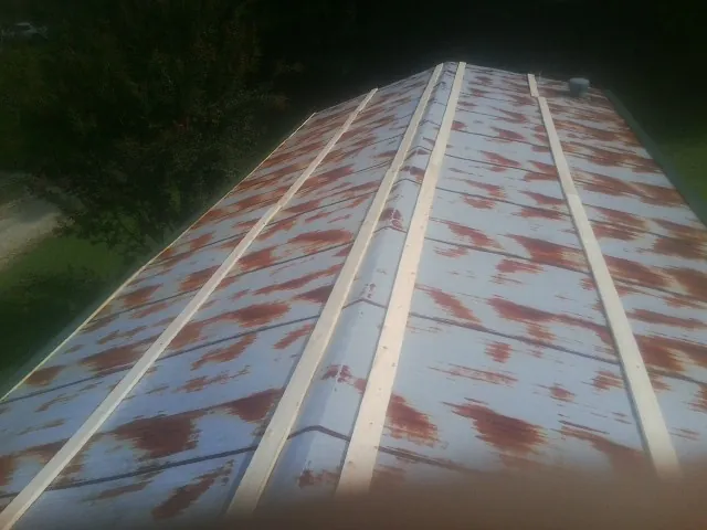 Rusted metal roof panels with new wood purlins before replacement — Storm Damage Roof Repair in Olga by Roofing Brothers