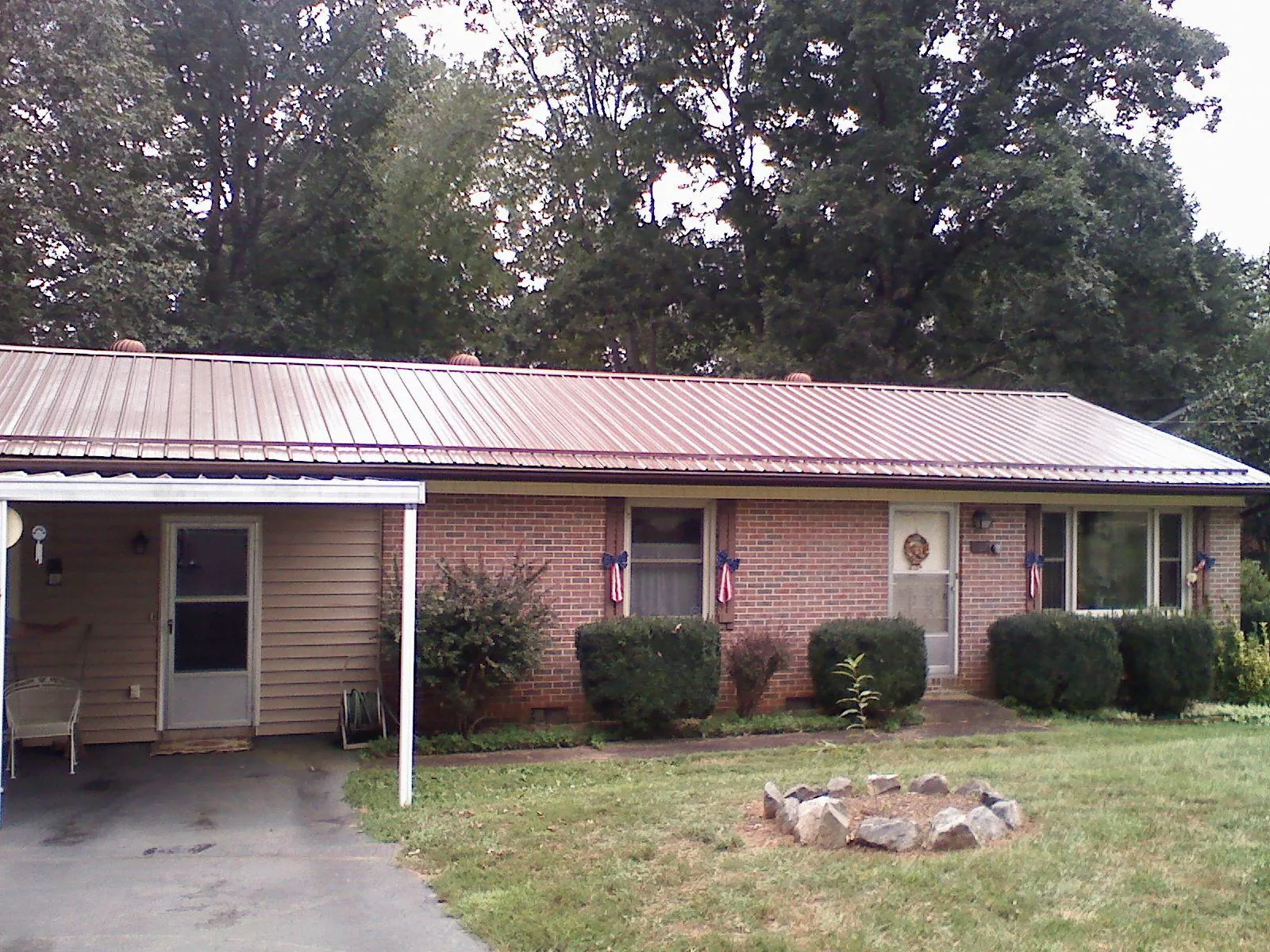 Bronze metal roof and carport on a brick ranch home — Roof Repair work by our crew in Olga